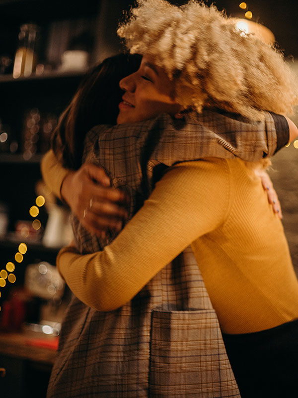 two-women-hugging-at-night