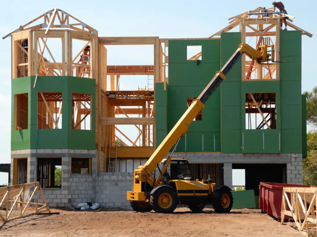 A house mid construction with green panels