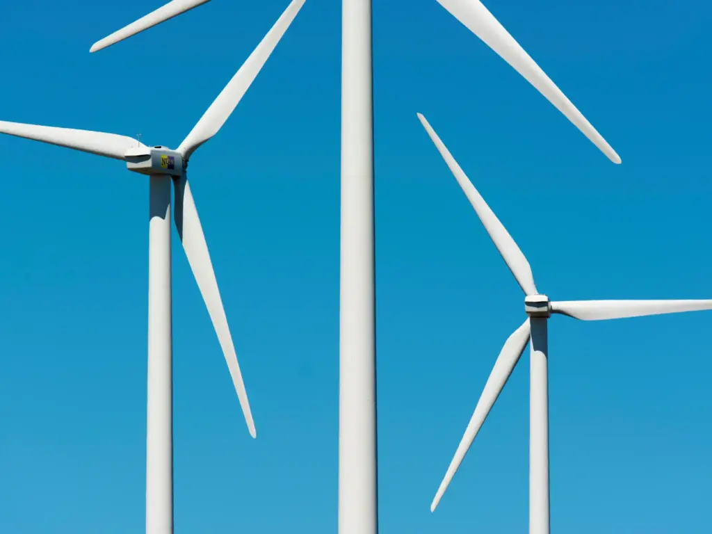 3 wind farm windmills against a blue sky